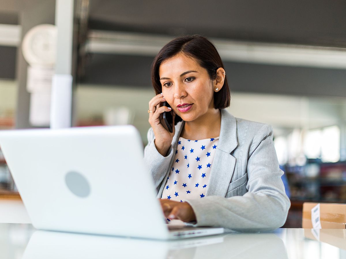 A small business owner talking on the telephone and looking at her computer