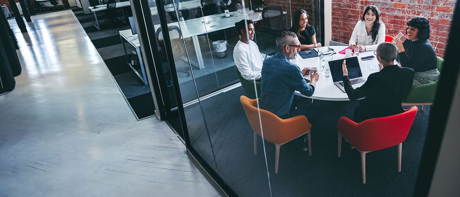 Business professionals discussing cyber security coverage in a modern conference room.