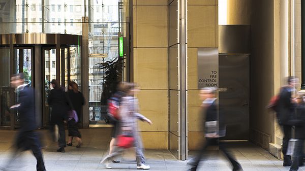 Busy sidewalk in front of a secure building.